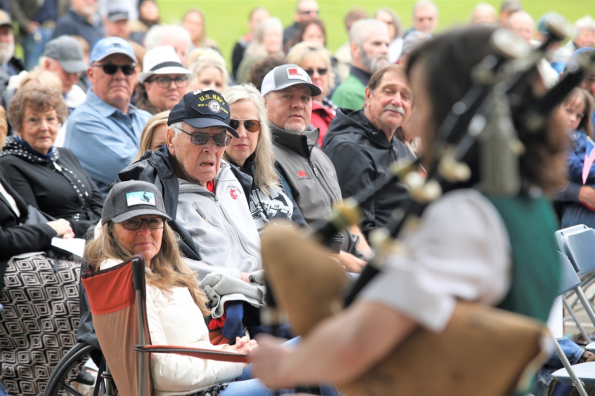 World War II Navy veteran Wiley C. Raulston is surrounded by family and friends as he listens to Kristin Stafford play "Amazing Grace" at McIntire Family Park on Monday.