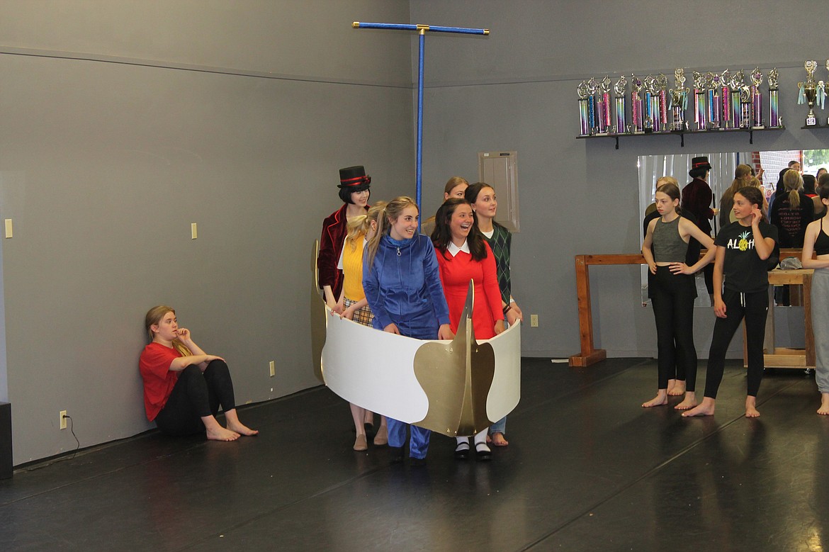 From left: Willy Wonka (Alyssa Kershner), Siri Cellphone (Reegan Radach, face hidden), Violet Beauregarde (Esther Roeber), Veruca Salt (Lily Schindler), Grandpa Joe (Jenna Laney, partly obscured in back) and Charlie Bucket (Madeline Voigt) ride a boat down a chocolate river in a rehearsal for “Willy Wonka.” The Ballet Academy of Moses Lake will be presenting the show Wednesday and Thursday.