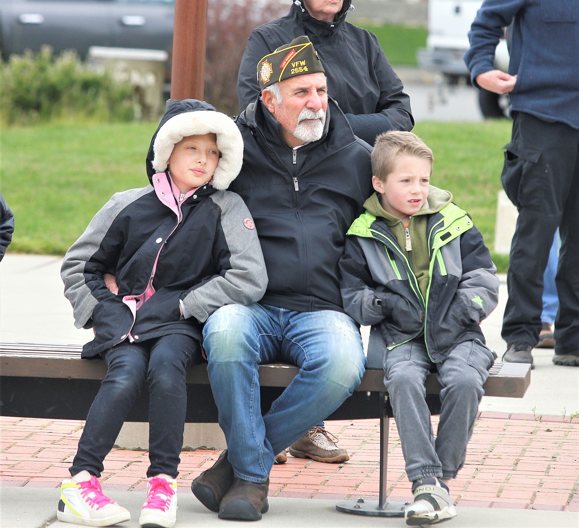 A veteran sits with children during the Memorial Day ceremony at Veterans Memorial Plaza at McEuen Park.