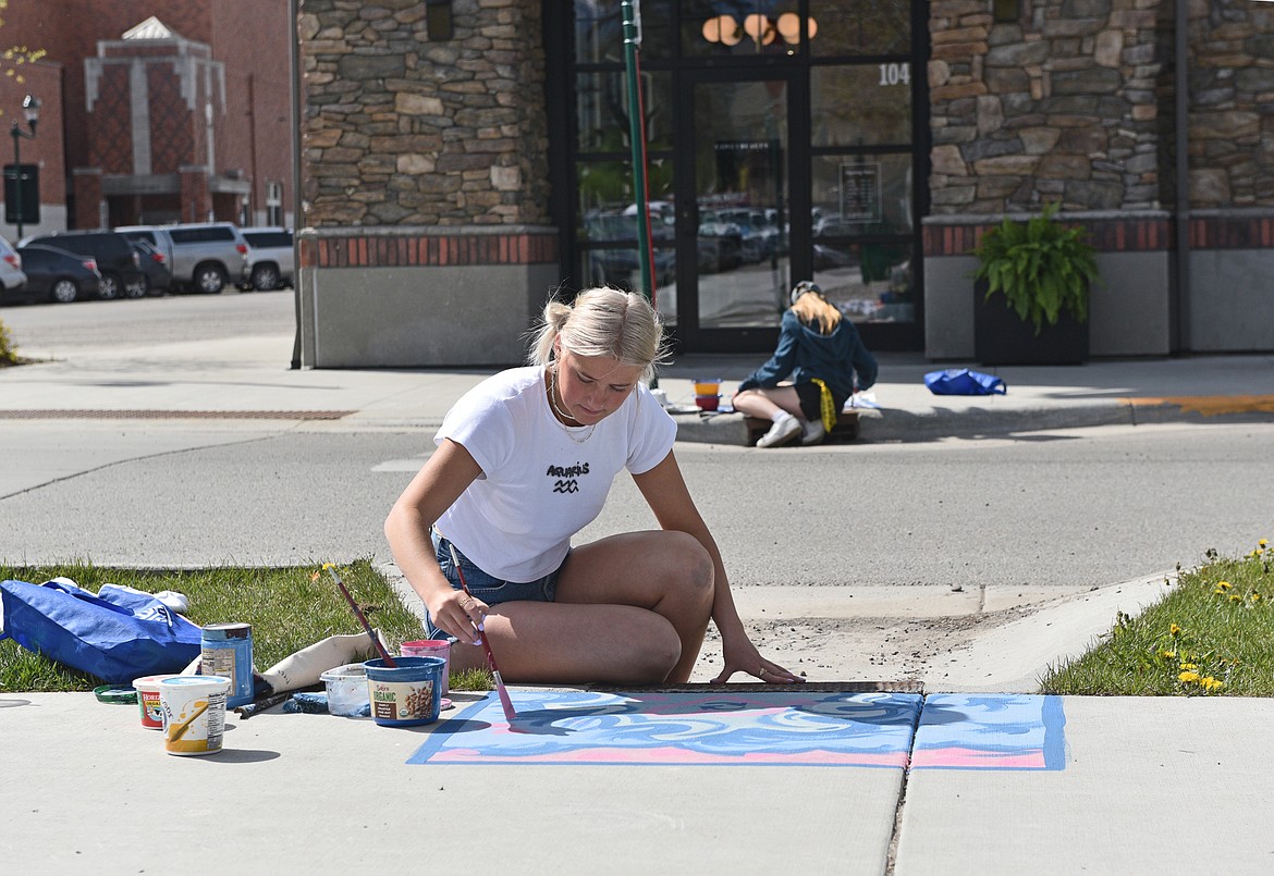 Whitefish High School's Advanced Art students Piper Dudley painting her mural on a downtown storm drain. (Julie Engler/Whitefish Pilot)