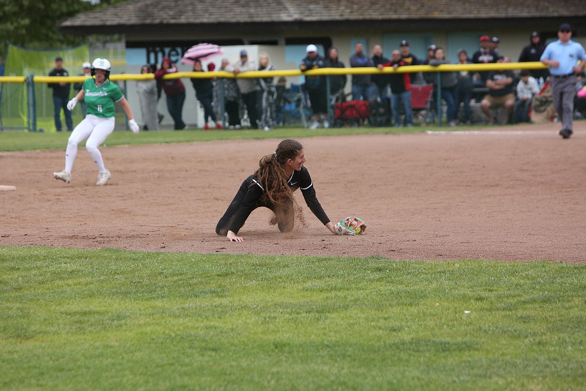 Othello junior Camryn McDonald dives after a hit ball in the infield before throwing it to first base for an out on May 28, 2022.