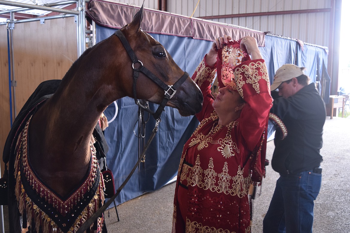 Carol Rasmussen lifts up her veil to say hello to her horse Snickers as the two prepare to compete Saturday evening during the Inland Empire Arabian Horse Club’s annual four-day Memorial Day Classic. Rasmussen is one of four competitors who showed off their riding skills while wearing “native costume.”