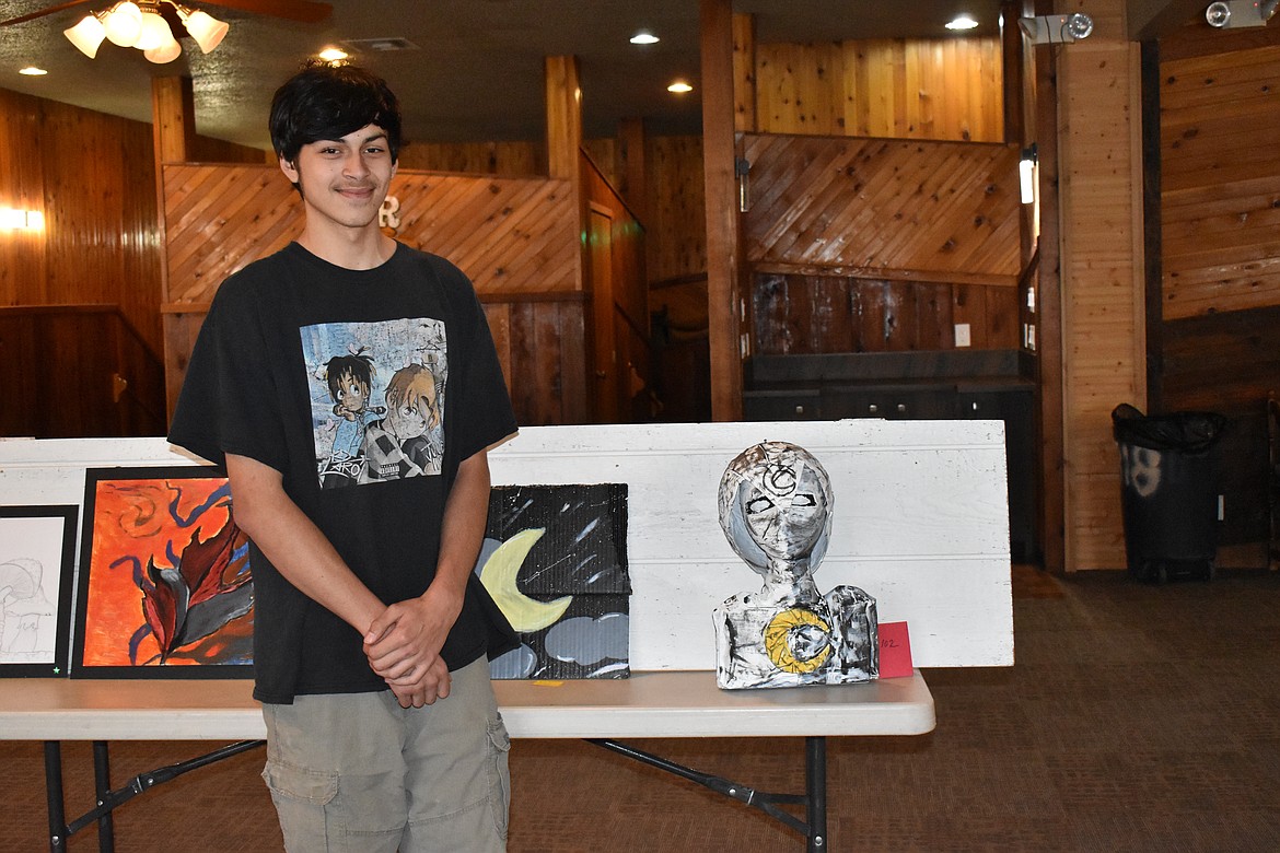 Jaidon stands in front of his art which was a tribute to the Marvel character, Moon Knight. It was made with foam and paper mache.