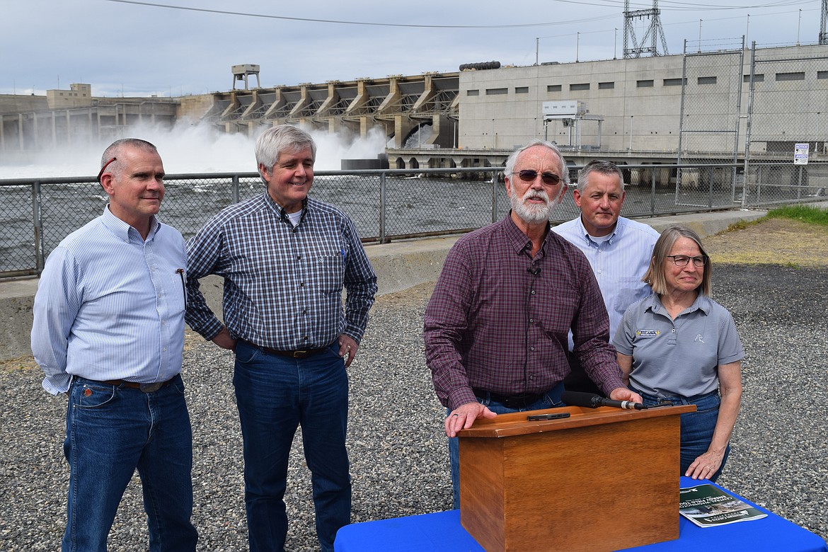 Rep. Dan Newhouse, speaking at the podium, is joined in front of the Ice Harbor Dam by representatives (left to right) Matt Rosendale, R.-Mont., Cliff Bentz, R-Ore., Bruce Westerman, R-Ark., and Marinnette Miller-Meeks, R-Iowa, following a tour of the dam and the powerhouse on Wednesday that highlighted the importance of the four lower Snake River dams to the Pacific Northwest.