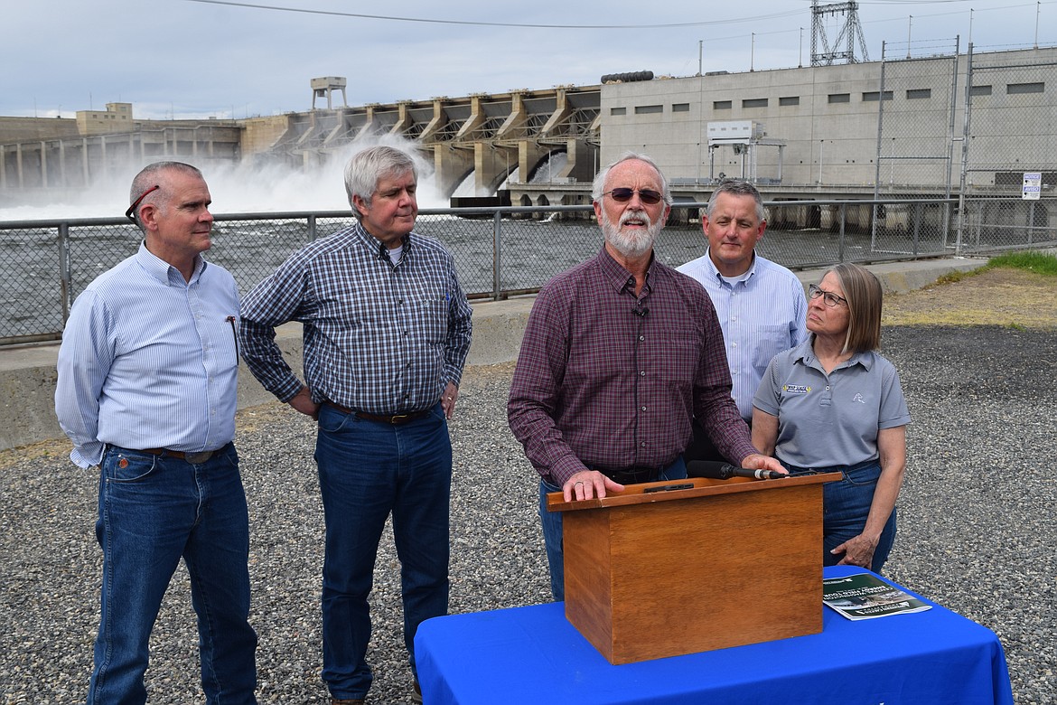 Rep. Dan Newhouse, speaking at the podium, is joined in front of the Ice Harbor Dam by representatives (left to right) Matt Rosendale, R.-Mont., Cliff Bentz, R-Ore., Bruce Westerman, R-Ark., and Marinnette Miller-Meeks, R-Iowa, following a tour of the dam and the powerhouse on Wednesday that highlighted the importance of the four lower Snake River dams to the Pacific Northwest.