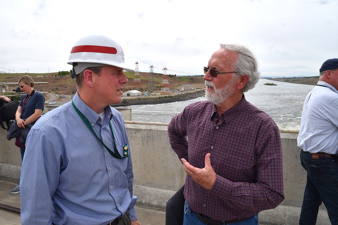 Rep. Dan Newhouse, R-Yakima, speaks with Alan Feister, a civilian manager with the Army Corps of Engineers, about the methods the corps has put in place at the Ice Harbor Dam to improve the survival prospects for salmon migrating upstream.