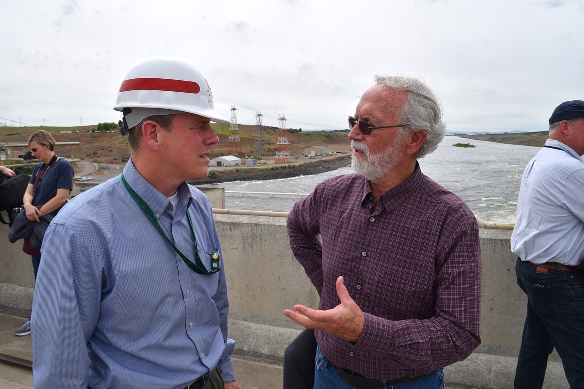 Rep. Dan Newhouse, R-Yakima, speaks with Alan Feister, a civilian manager with the Army Corps of Engineers, about the methods the corps has put in place at the Ice Harbor Dam to improve the survival prospects for salmon migrating upstream.