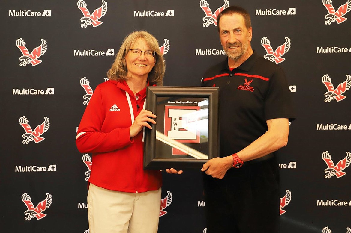 EWU’s track and field coaches pose with an award. Women’s coach Marcia Mecklenburg (left) and men’s coach Stan Kerr (right) have both spent 27 years at EWU.