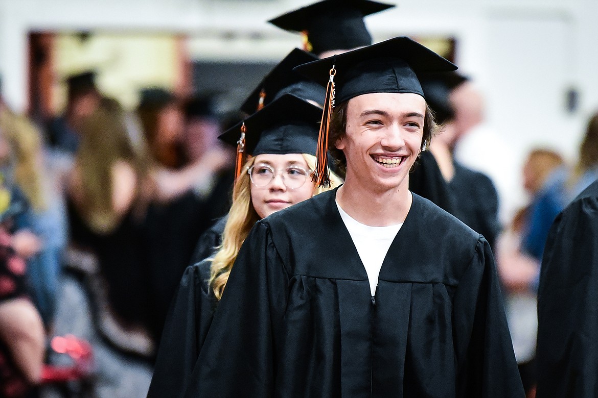 A graduate smiles as he and classmates file into the gymnasium for Flathead High School's Class of 2022 commencement ceremony on Friday, June 3. (Casey Kreider/Daily Inter Lake)