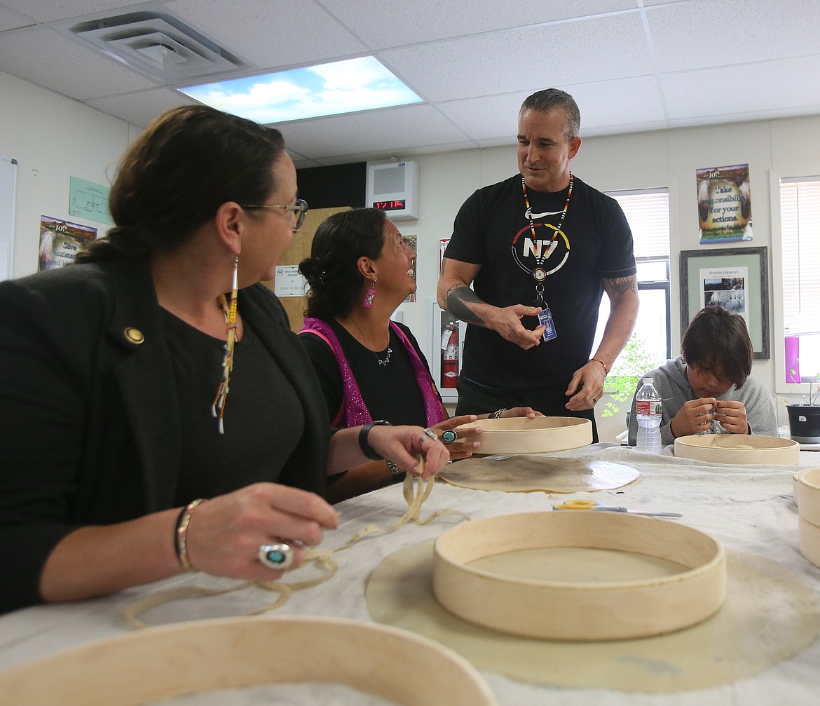 From left, officials from the United States Department of Education, Hollie Mackey and Amy Loyd, make traditional hand drums with the help of Coeur d'Alene Tribal School instructor Wade McGee and his students during a site visit Friday.