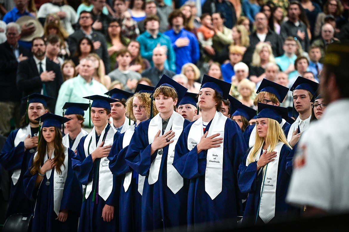 Graduates place their hands over their hearts during the color guard presentation by V.F.W. Post 2252 at Glacier High School's Class of 2022 commencement ceremony on Saturday, June 4. (Casey Kreider/Daily Inter Lake)