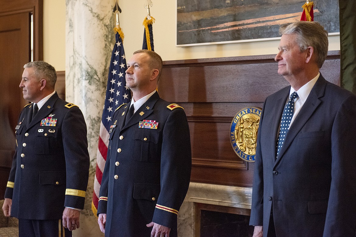 Adjutant General of Idaho Maj. Gen. Michael Garshak, Col. Ryan Robinson and Gov. Brad Little prepare for the publishing of the order promoting Robinson to the rank of brigadier general, at a ceremony held June 2, at the state capitol in Boise.