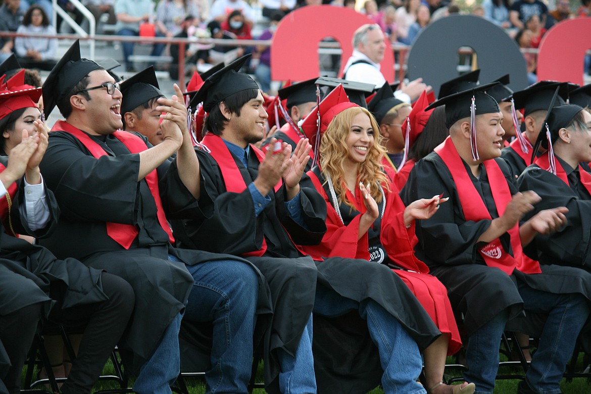 Seniors applaud ASB president Zak Rocha after his speech during Friday’s Othello High School graduation.