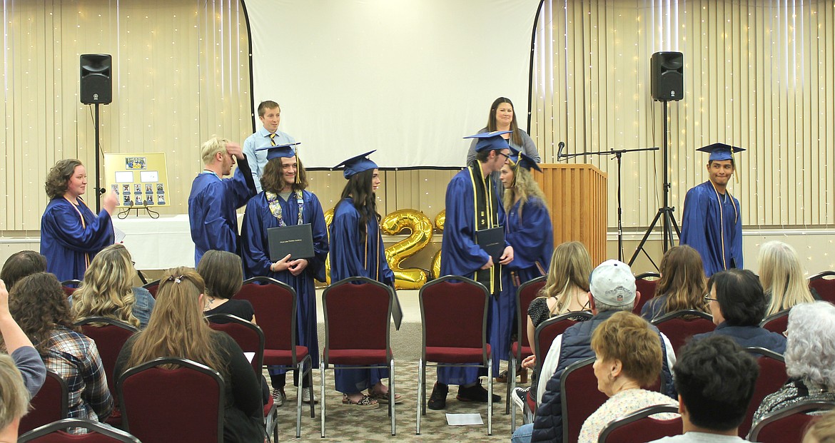 Members of the Moses Lake Christian Academy Class of 2022 prepare to go forth in the world Saturday. From left: Rebecca Starcher, Jacob Robertson, Landon Pruett, Aspen Merkle, Christian Hoefler, Kaylin Hampton and David Chavez. Behind them are class advisor Brendan Thompson and Director of Teaching and Learning Crystal Kast.