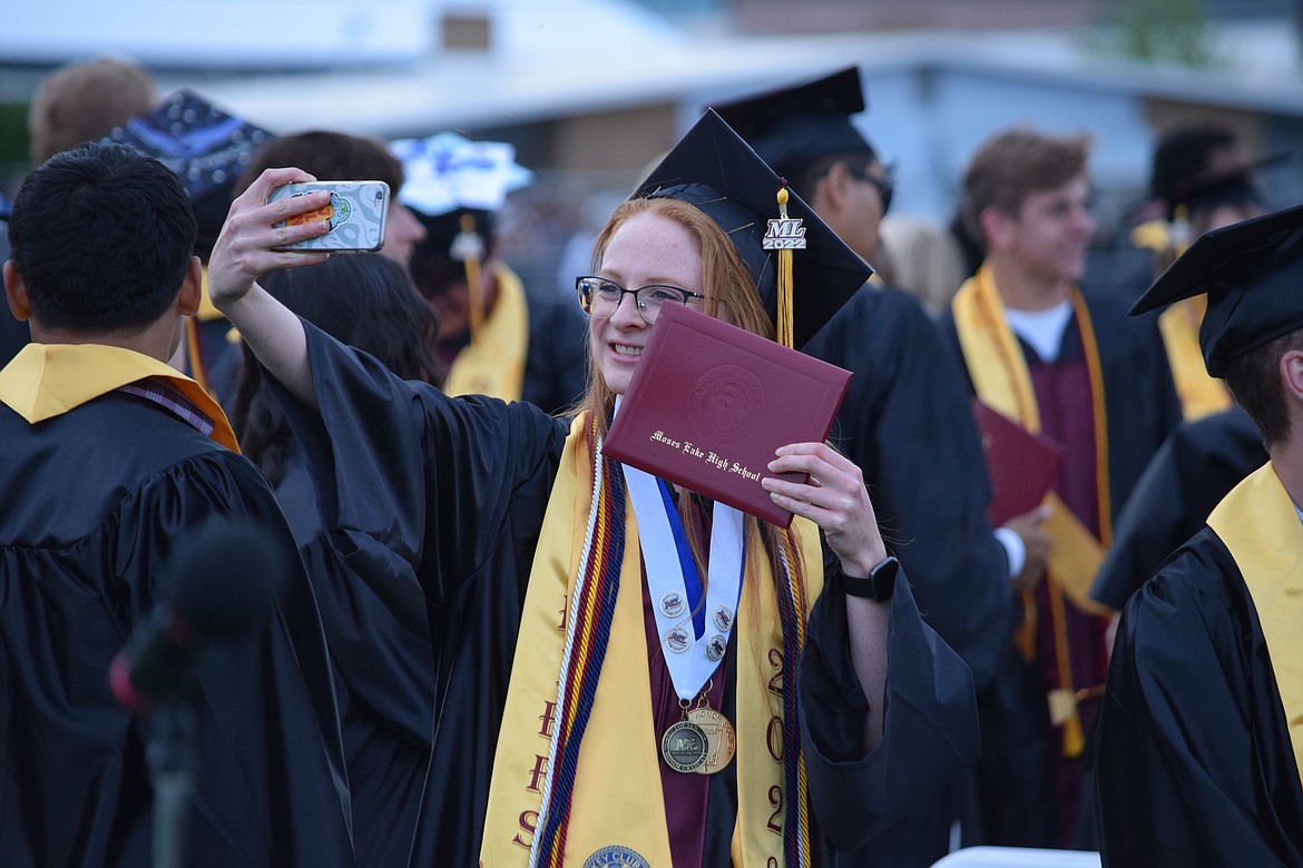 A Moses Lake High School Senior takes a selfie following the school’s graduation ceremony on Friday — the first on Lion’s Field since 2019.