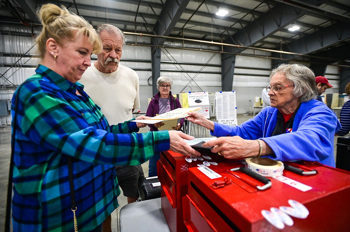 Brenda and Jim Roy pass their ballots to Jean Cross, an election official with Flathead County, at the Flathead County Fairgrounds on Tuesday, June 7. (Casey Kreider/Daily Inter Lake)