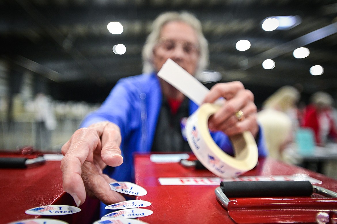Jean Cross, an election official with Flathead County, places stickers out for voters in the primary election at the Flathead County Fairgrounds in Kalispell on Tuesday, June 7. (Casey Kreider/Daily Inter Lake)