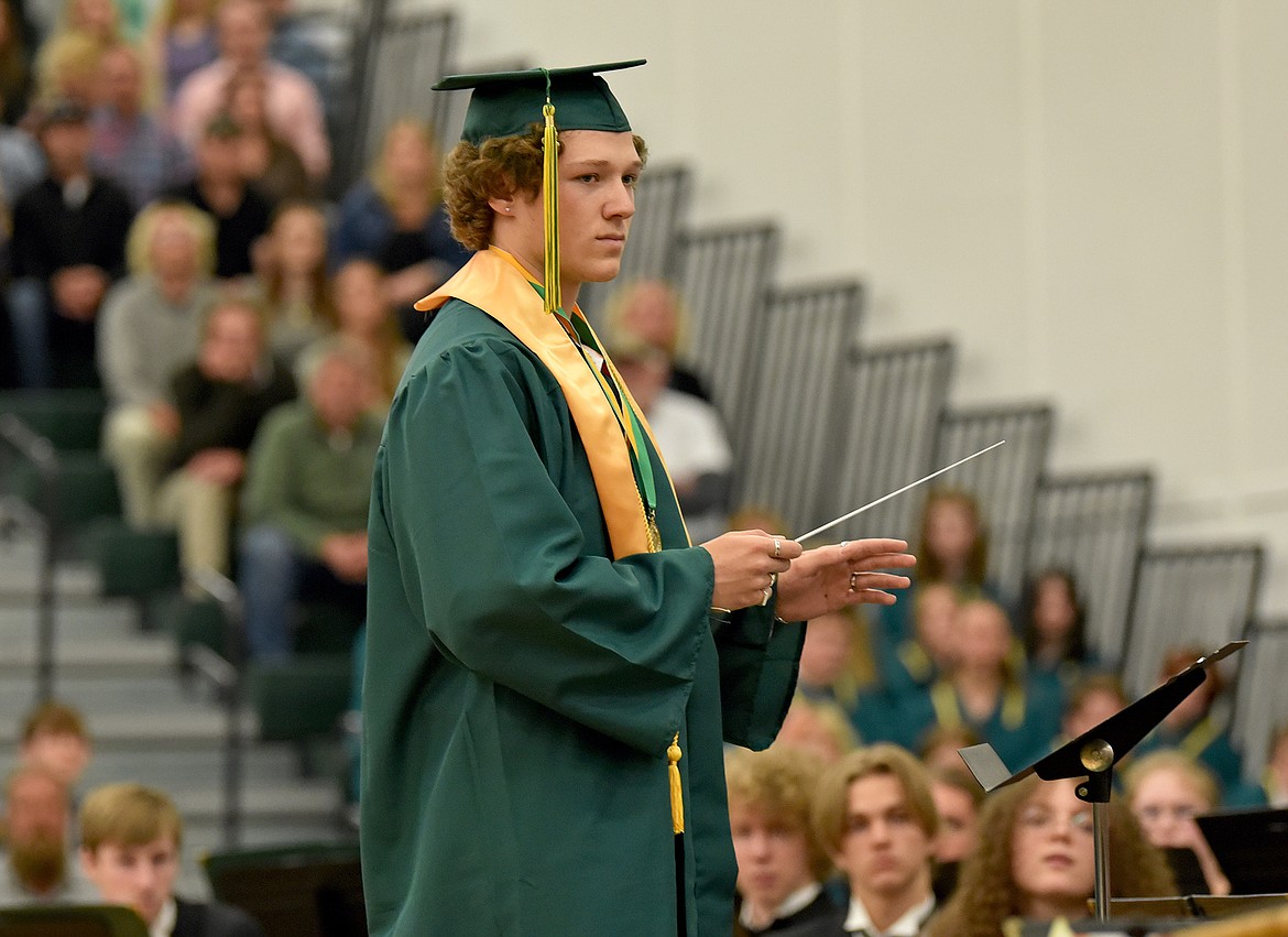 Graduate Willem Gray of the Whitefish High School Class of 2022 conducts the high school orchestra during a commencement ceremony at the high school gym. (Whitney England/Whitefish Pilot)