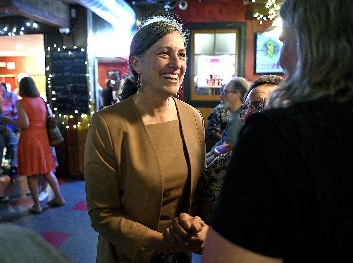 Montana Democratic U.S. House candidate Monica Tranel talks with a supporter during an election watch event at the Union Club Bar & Grille in Missoula, Mont., on Tuesday, June 7, 2022. Tranel defeated Cora Neumann and state Rep. Tom Winter in Tuesday’s primary. (Tom Bauer/The Missoulian via AP)