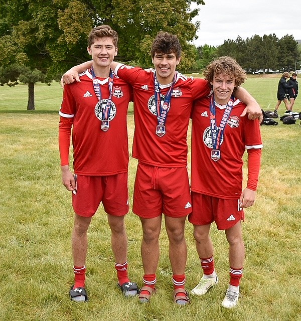 Three Sandpoint High School soccer players pose following their win at the Idaho State Cup. Pictured, from left, are  Evan Dickinson, Stirling Roget, and Jett Longanecker