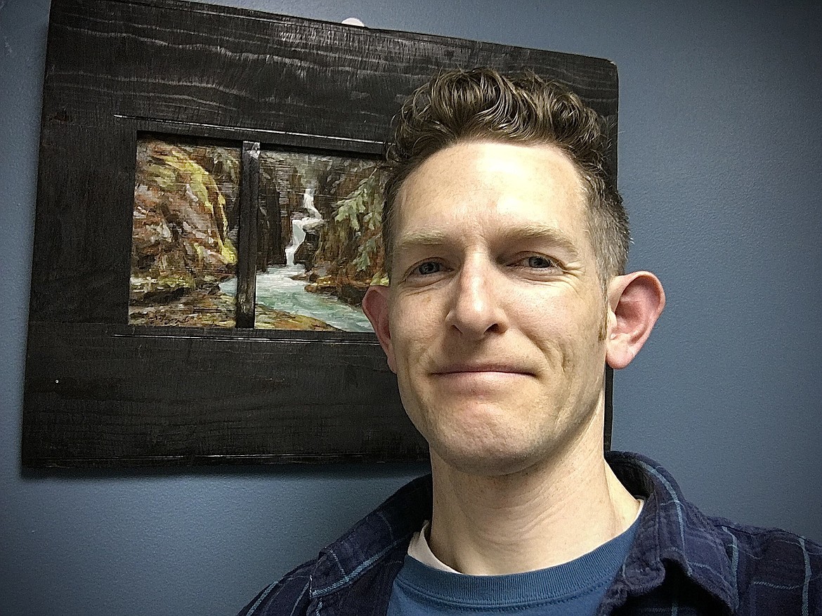 Fine artist and educator James Johnson stands beside one of his oil paintings at Paint, Metal and Mud Gallery in Kalispell.