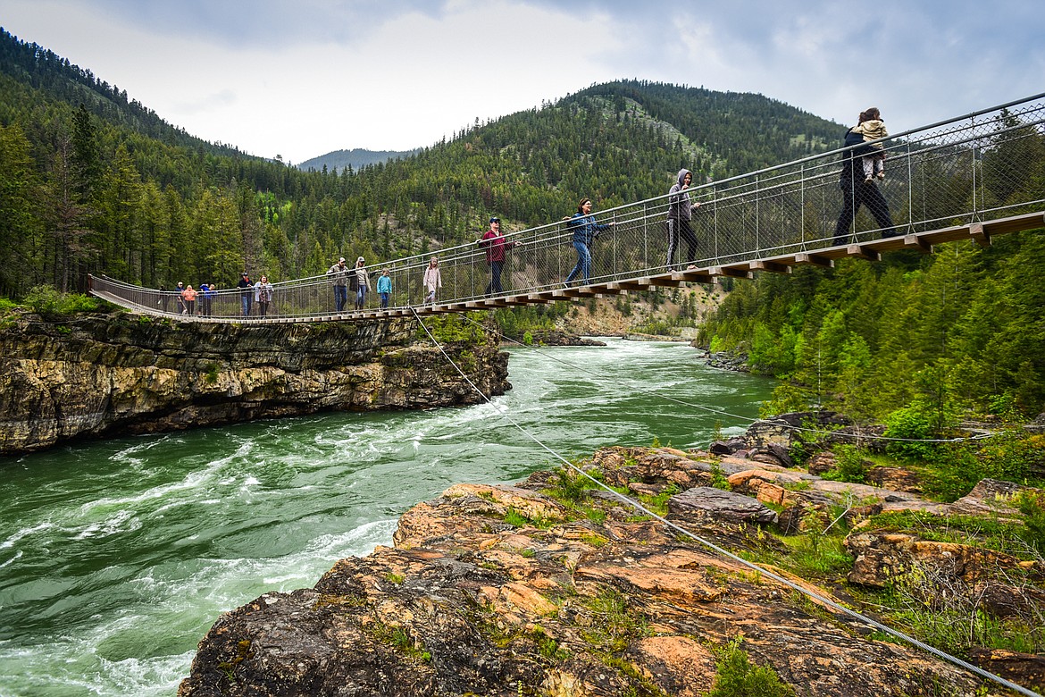 Visitors walk along the Kootenai Falls Swinging Bridge near Libby on Sunday, May 29. (Casey Kreider/Daily Inter Lake)