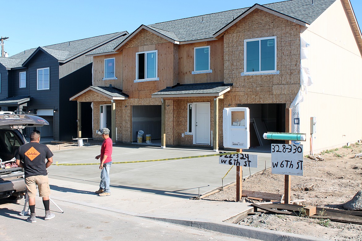 Two workers get ready to go to work on a duplex under construction on West Sixth Street in Warden. The construction is part of the Warden Heights development.