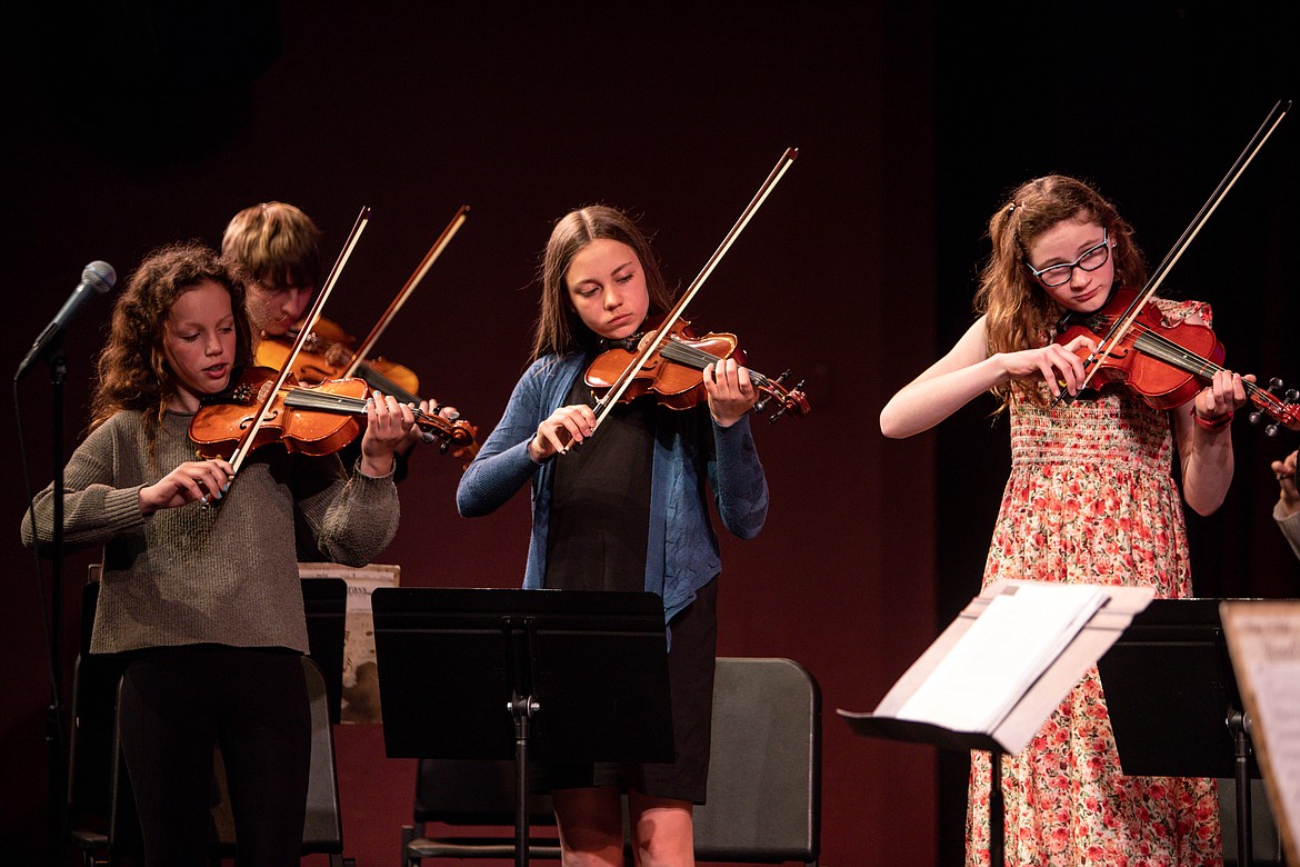 Seventh graders Alina Pohlman, Treyton Butterfield (behind), Savy Evans, Edolie Petersen play the violin. (JP Edge photo)