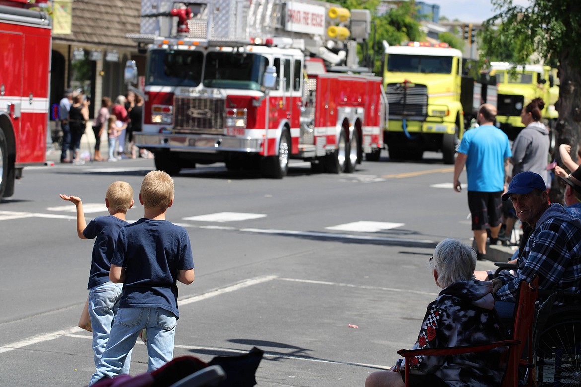 Colton Cook (left foreground) and Jackson Cook (right foreground) watch the fire trucks go by at the 2021 Sage-N-Sun parade in Ephrata. Sage-N-Sun returns tonight and tomorrow.