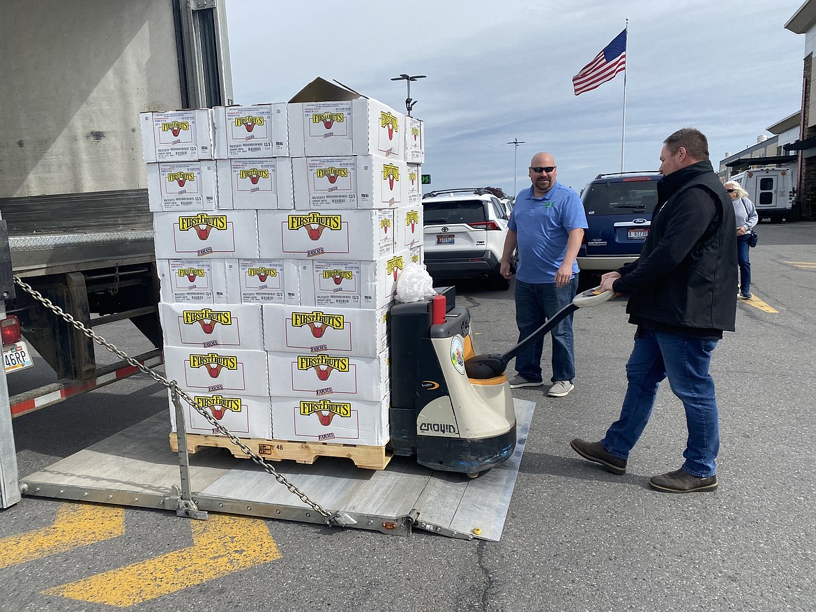 Ned Hughes, left, and Eric Ogrin from Charlie's Produce load about half of the apples donated to Community Action Partnership Coeur d'Alene food bank Thursday morning. The over 3,000-pound donation was made possible by a cooperative effort between Super 1 Foods, Charlie's Produce and FirstFruits Farm.