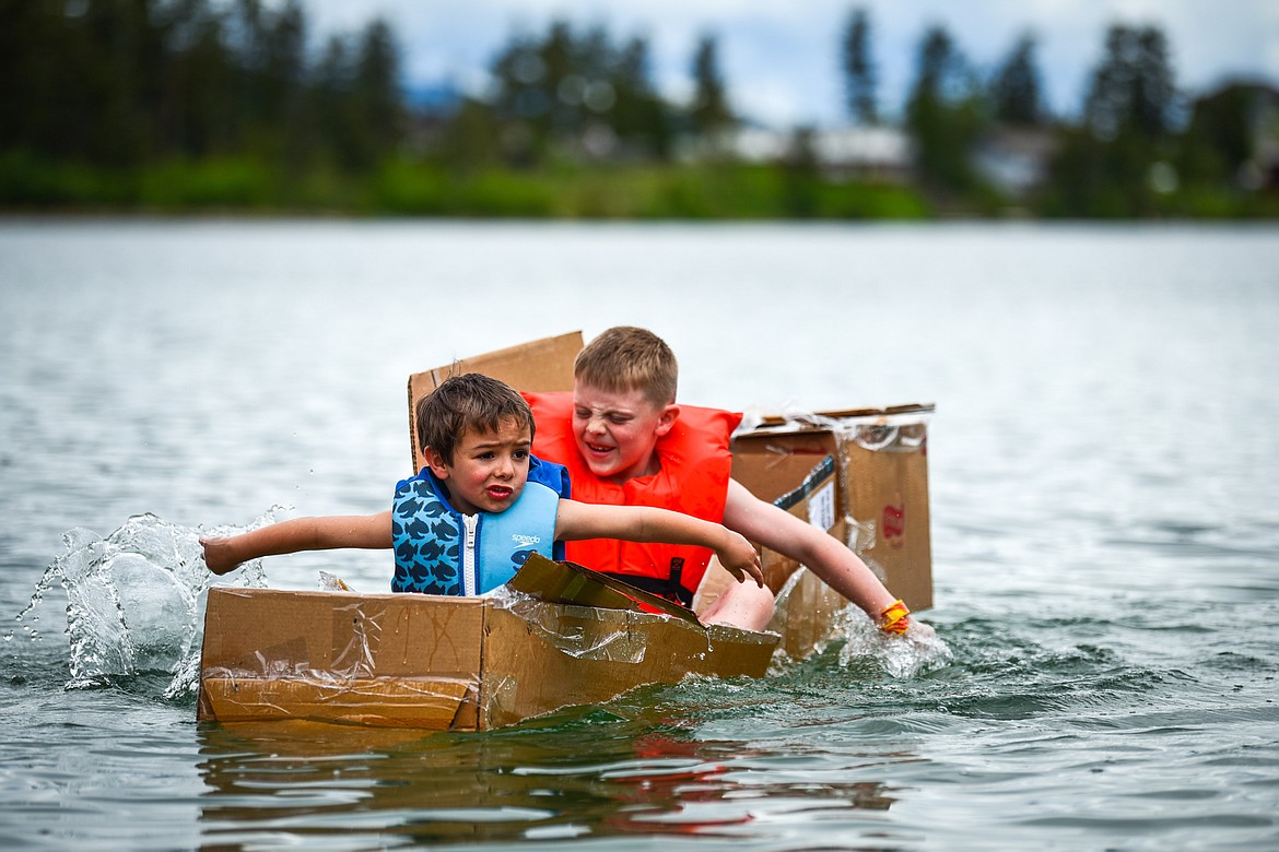 St. Matthew's School first-grader Vinnie Francischetty, left, and second-grader Blaine Bubar paddle their homemade cardboard boat around Foy's Lake on Friday, June 10. As part of St. Matthew's Jump Into Summer Science Program hosted by teacher Susie Rainwater, 47 students in grades 1-5 used applied science and math concepts to construct their crafts and test their buoyancy in the waters of Foy's Lake. (Casey Kreider/Daily Inter Lake)