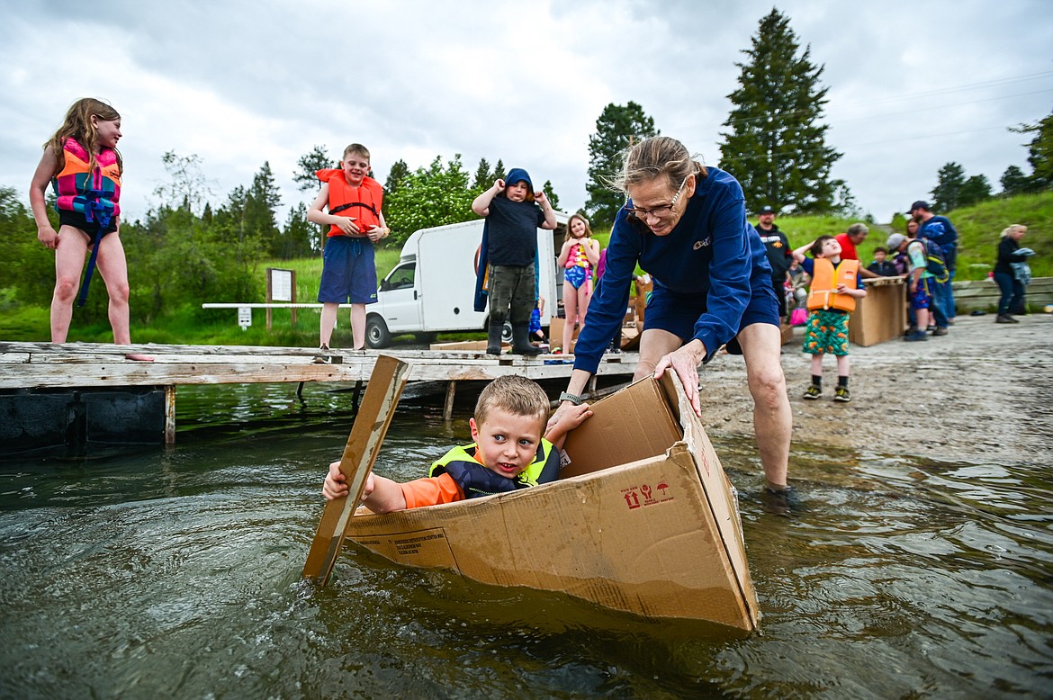 St. Matthew's School first-grader Carter Borges paddles his homemade cardboard boat into Foy's Lake on Friday, June 10. As part of St. Matthew's Jump Into Summer Science Program hosted by teacher Susie Rainwater, 47 students in grades 1-5 used applied science and math concepts to construct their crafts and test their buoyancy in the waters of Foy's Lake. (Casey Kreider/Daily Inter Lake)