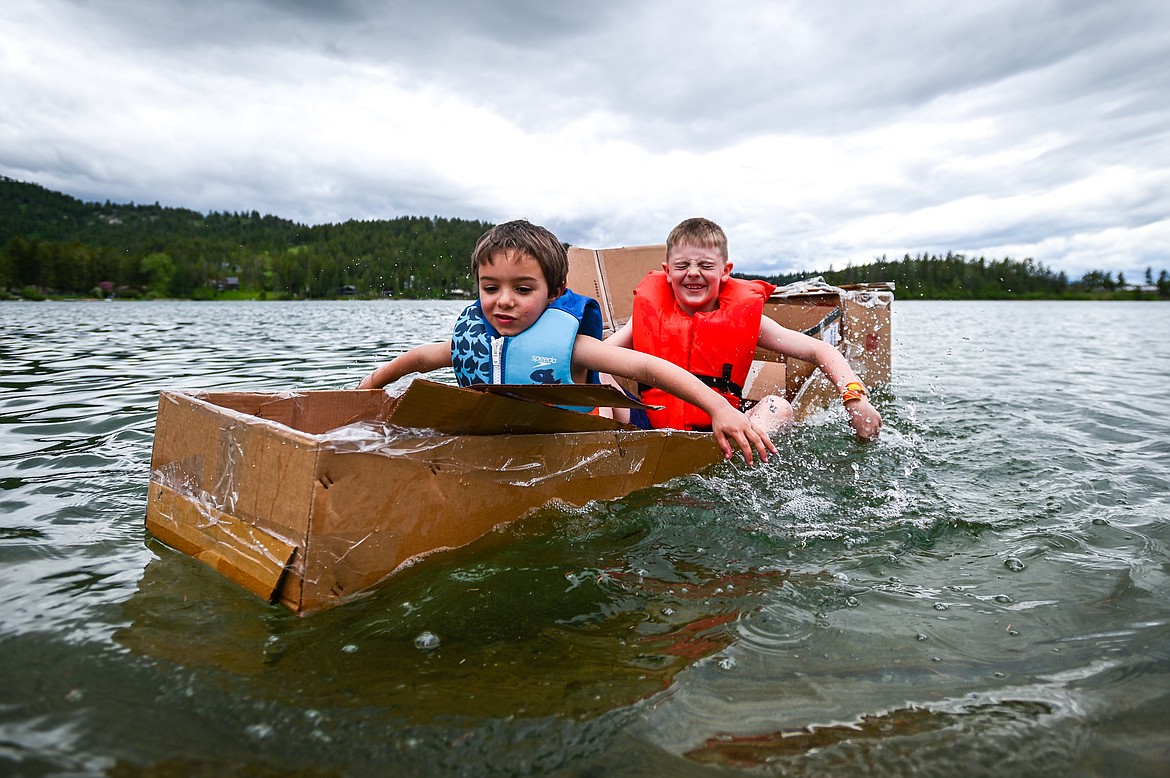 St. Matthew's School first-grader Vinnie Francischetty, left, and second-grader Blaine Bubar paddle their homemade cardboard boat around Foy's Lake on Friday, June 10. As part of St. Matthew's Jump Into Summer Science Program hosted by teacher Susie Rainwater, 47 students in grades 1-5 used applied science and math concepts to construct their crafts and test their buoyancy in the waters of Foy's Lake. (Casey Kreider/Daily Inter Lake)