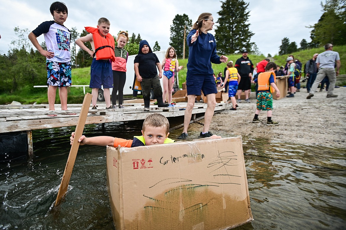 St. Matthew's School first-grader Carter Borges paddles his homemade cardboard boat into Foy's Lake on Friday, June 10. As part of St. Matthew's Jump Into Summer Science Program hosted by teacher Susie Rainwater, 47 students in grades 1-5 used applied science and math concepts to construct their crafts and test their buoyancy in the waters of Foy's Lake. (Casey Kreider/Daily Inter Lake)