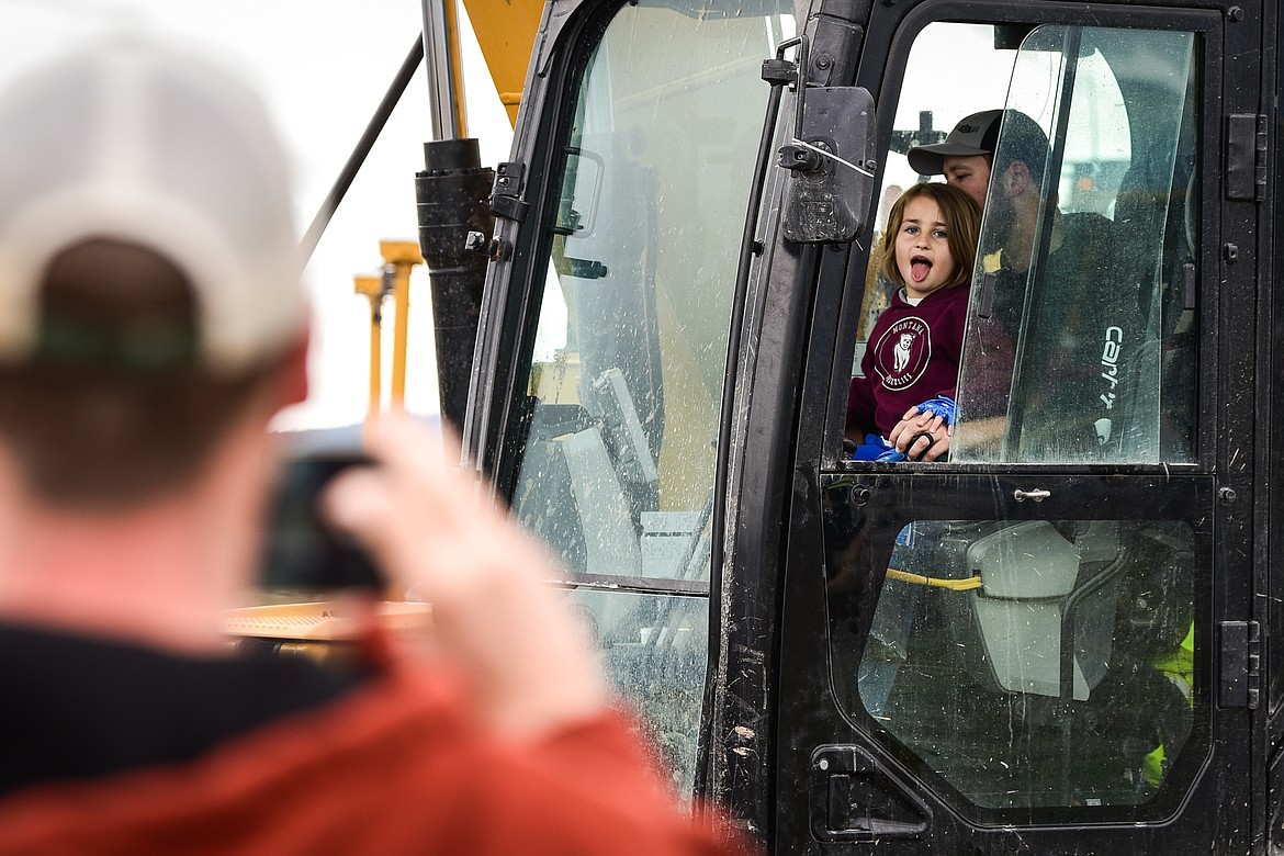 Seren Pickel sticks her tongue out inside an excavator as her father Kraig records her on his phone at the DIG Rotary event held by Kalispell Daybreak and Noon Rotary Clubs and LHC at the Kalispell North Town Center on Highway 93
and Rose Crossing on Saturday, June 11. Attendees got the opportunity to operate excavators, bulldozers and graders with proceeds going toward the creation of a Splash Pad full of sprayers, showers and water features along the Kalispell Parkline Trail. (Casey Kreider/Daily Inter Lake)