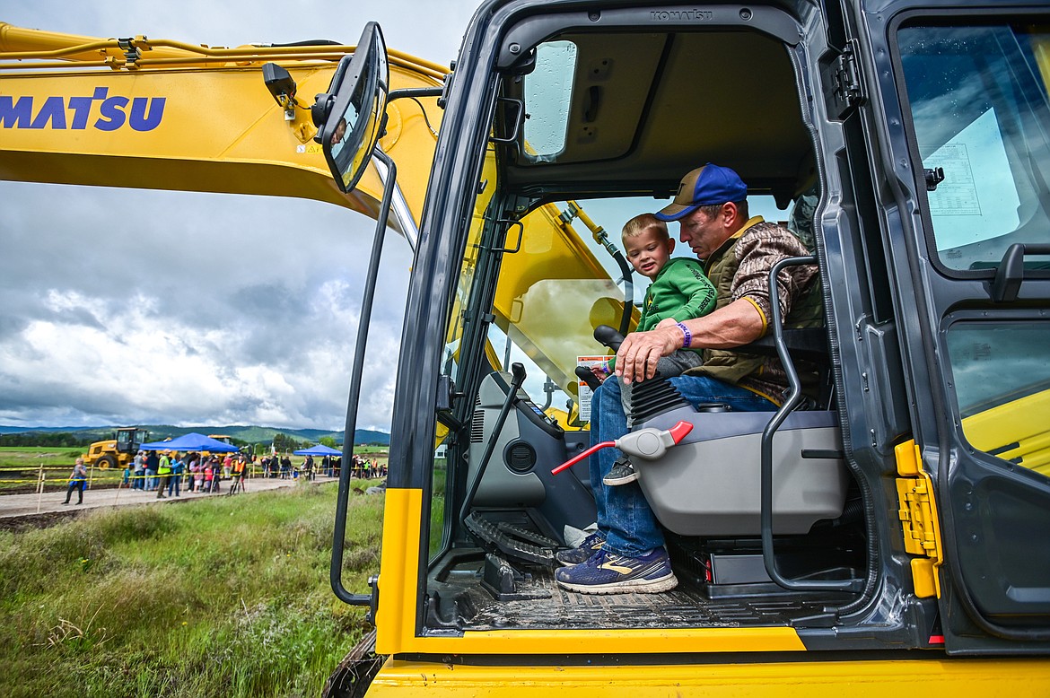 Cannon Dunn, 3, works inside an excavator with Bruce Roberts at the DIG Rotary event held by Kalispell Daybreak and Noon Rotary Clubs and LHC at the Kalispell North Town Center on Highway 93 and Rose Crossing on Saturday, June 11. Attendees got the opportunity to operate excavators, bulldozers and graders with proceeds going toward the creation of a Splash Pad full of sprayers, showers and water features along the Kalispell Parkline Trail. (Casey Kreider/Daily Inter Lake)