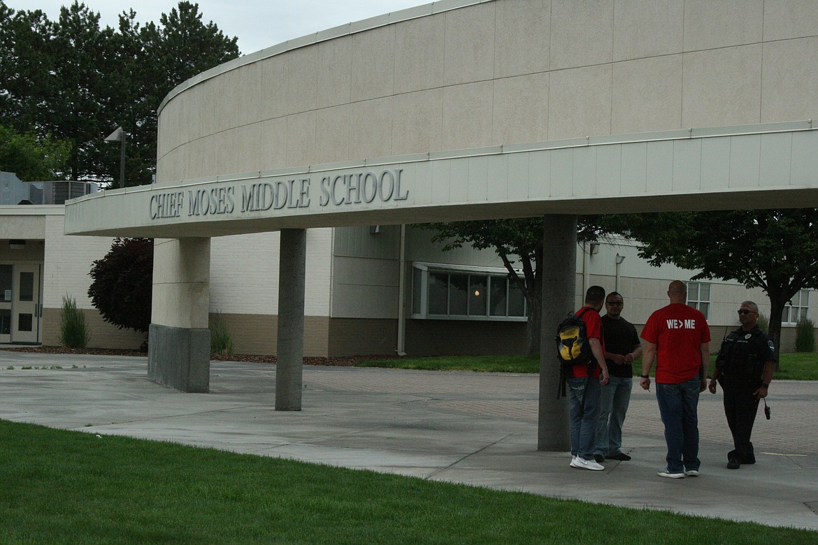 Chief Moses Middle School teachers and school personnel stop to talk under the facade at the school’s entry. Moses Lake School Board members voted to change the school’s name Thursday.