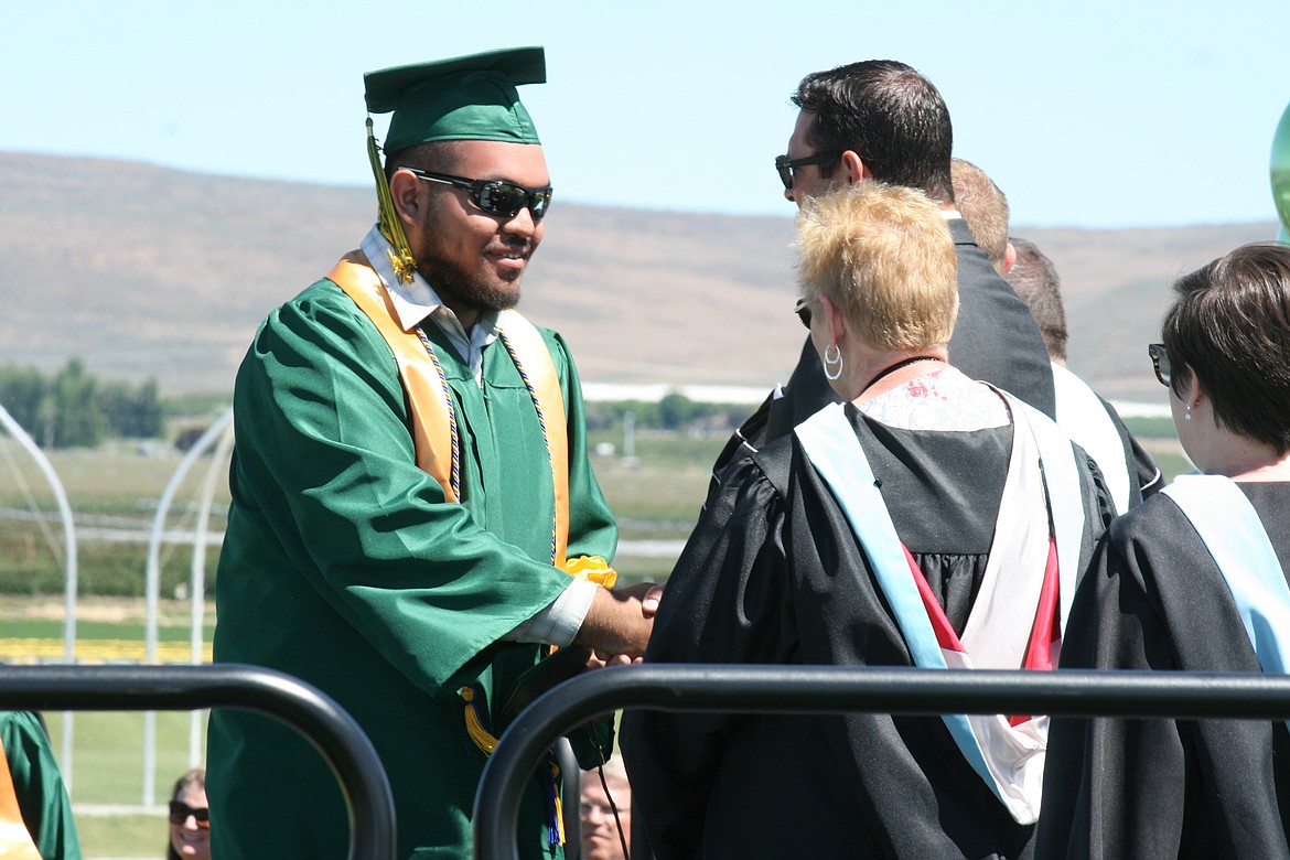 A Quincy High School graduate gets congratulations on his accomplishment during Saturday’s ceremony.