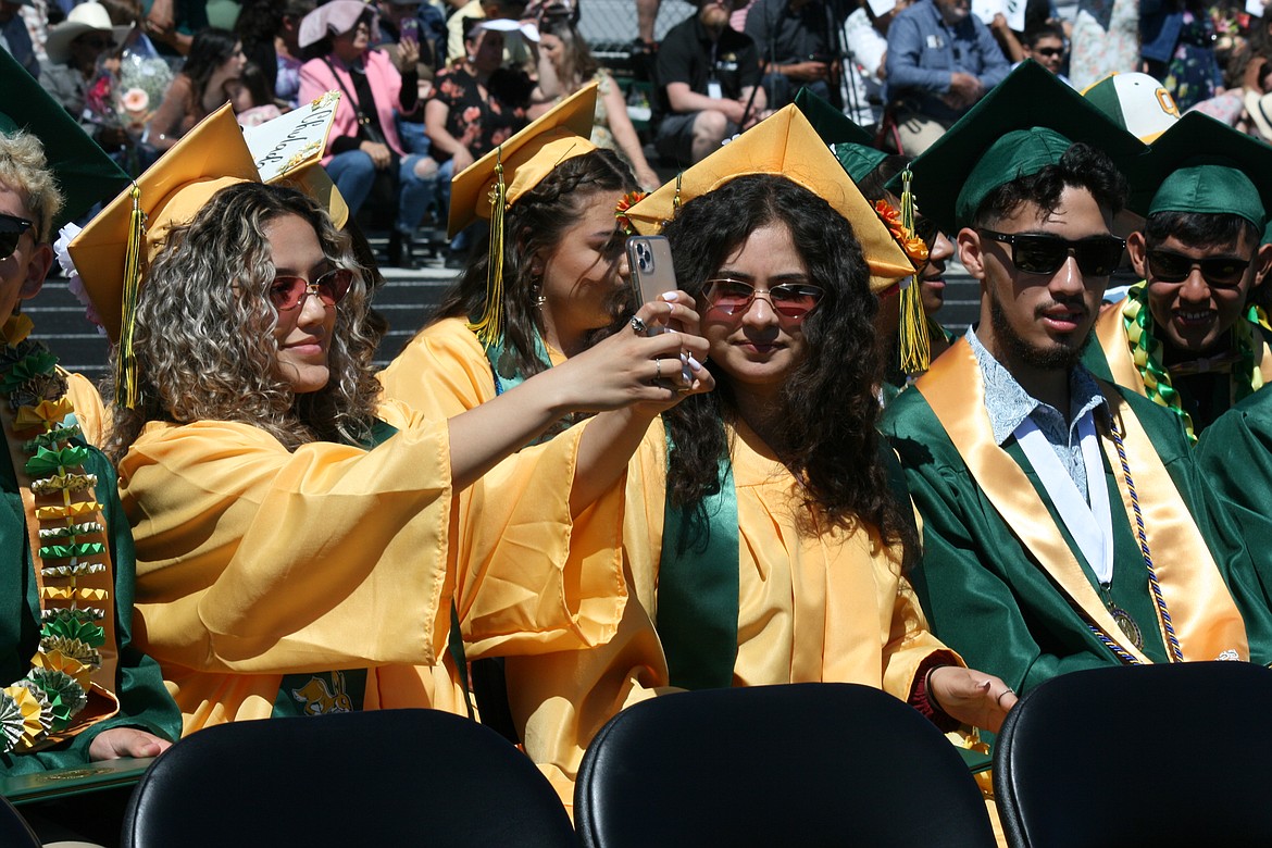 Diploma in her lap, a brand-new Quincy High School graduate snaps a selfie during 2022 graduation Saturday.