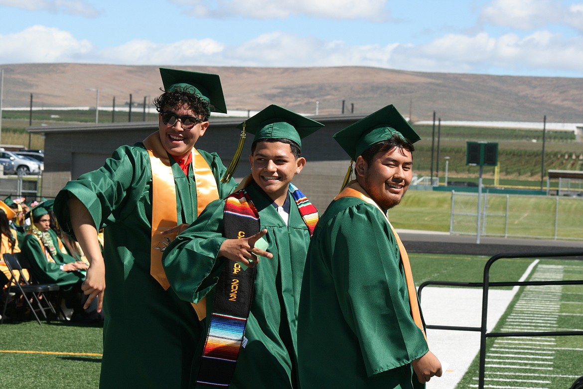 Quincy High School seniors acknowledge friends and family in the crowd during the entry into the stadium Saturday.