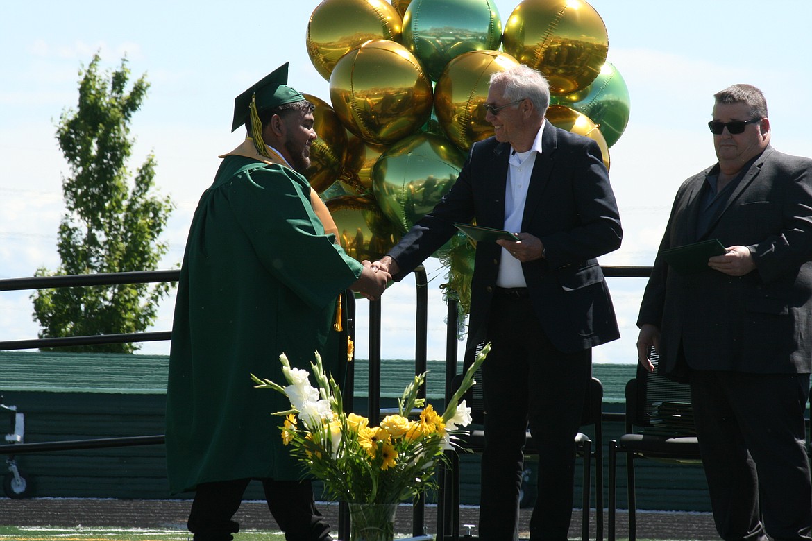 Graduation moment - a Quincy High School senior gets a handshake and, most importantly, his diploma.