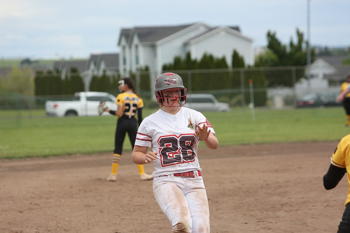 A dirtied Washington Rage player begins to slide into third after advancing on a wild pitch.