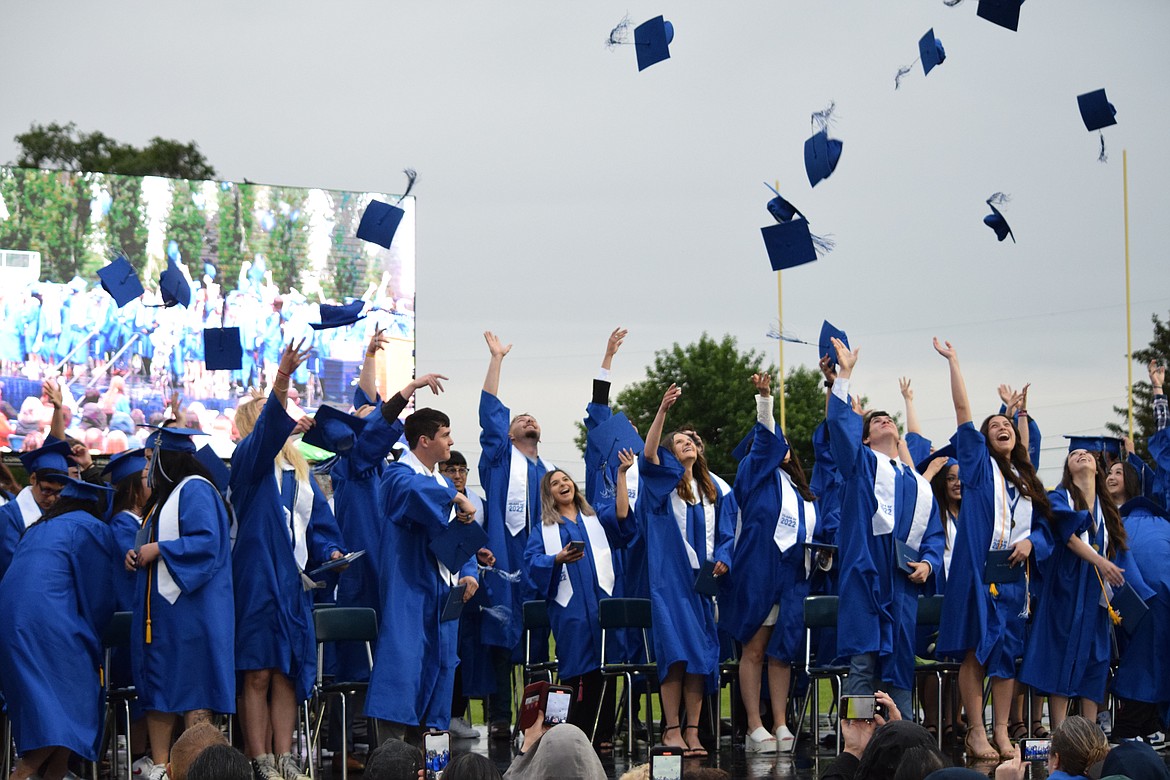 Warden High School graduates toss their caps into the air at the end of the class of 2022’s graduation ceremony Friday evening, held in the WHS football stadium despite the rain.