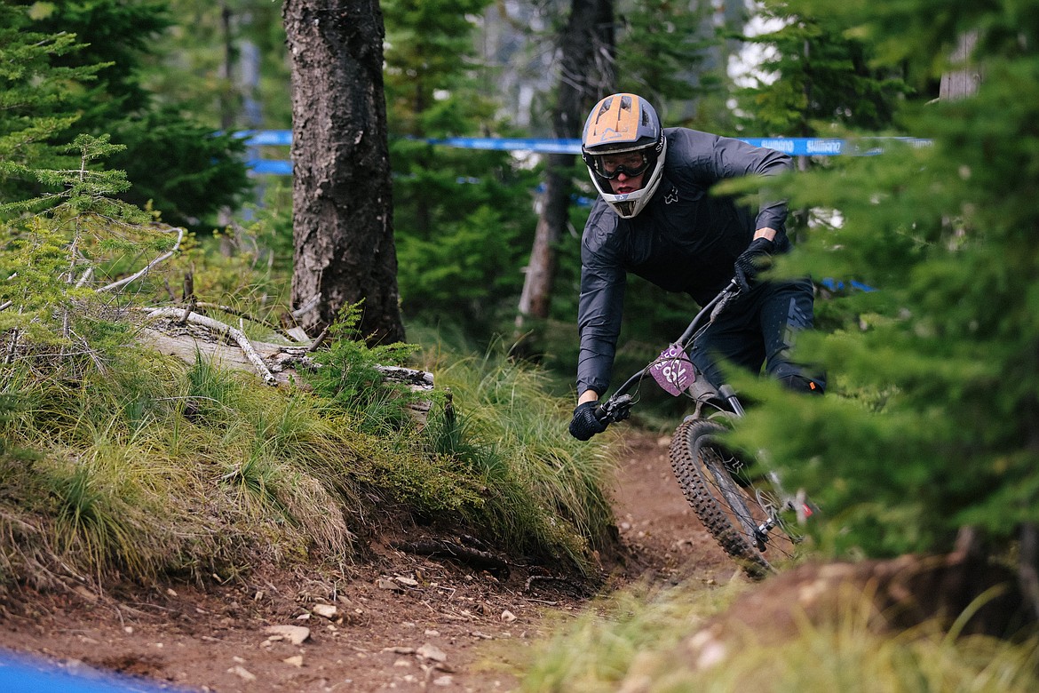 A mountain biker descends through the muddy trail.