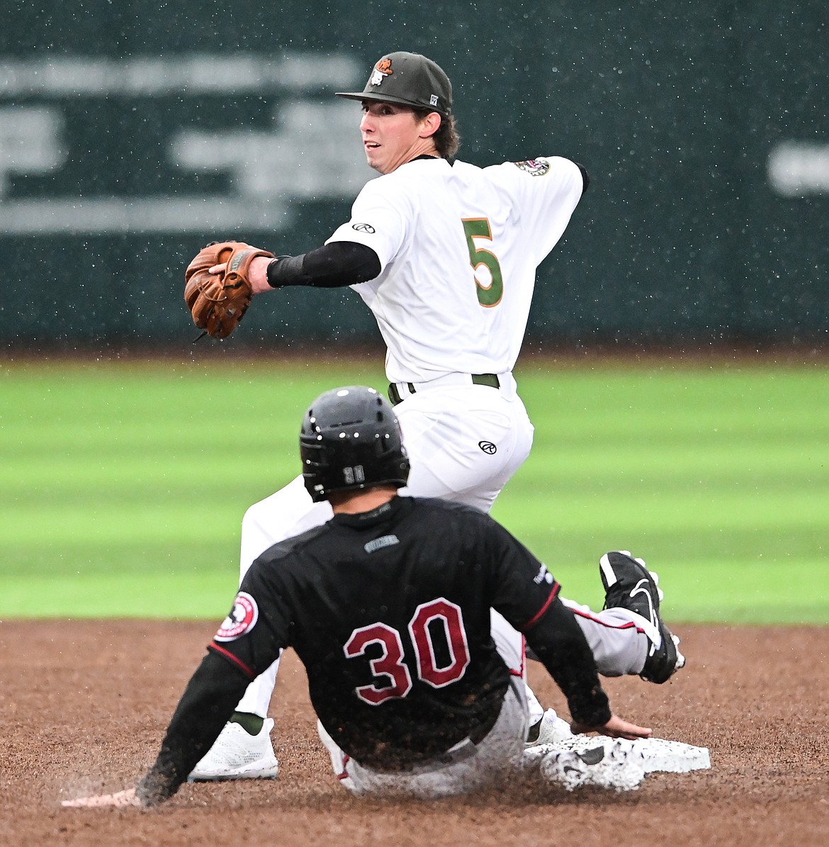 Glacier second baseman Ryan Cash (5) looks to first to turn a double play but holds on to the throw against the Billings Mustangs at Flathead Field on Tuesday, June 14. (Casey Kreider/Daily Inter Lake)