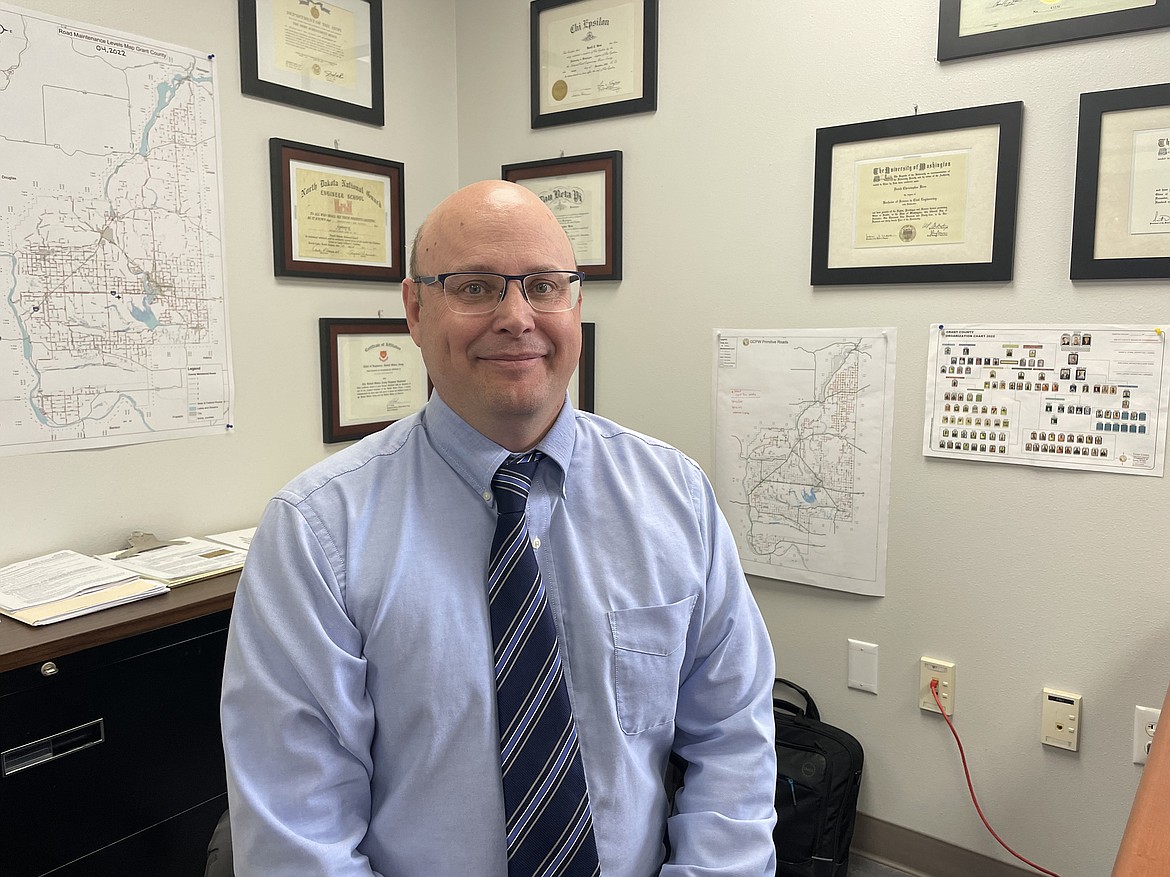 Grant County Engineer David Bren in his office, surrounded by diplomas, certificates and maps of the roads of Grant County.