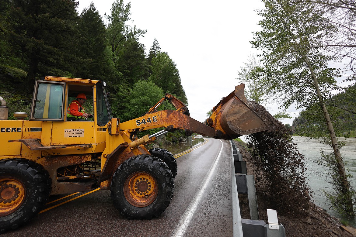 A tractor dumps gravel to reinforce U.S. 2 in Bad Rock Canyon after flooding left the road partially underwater Wednesday, June 15. (JP Edge/Hungry Horse News)