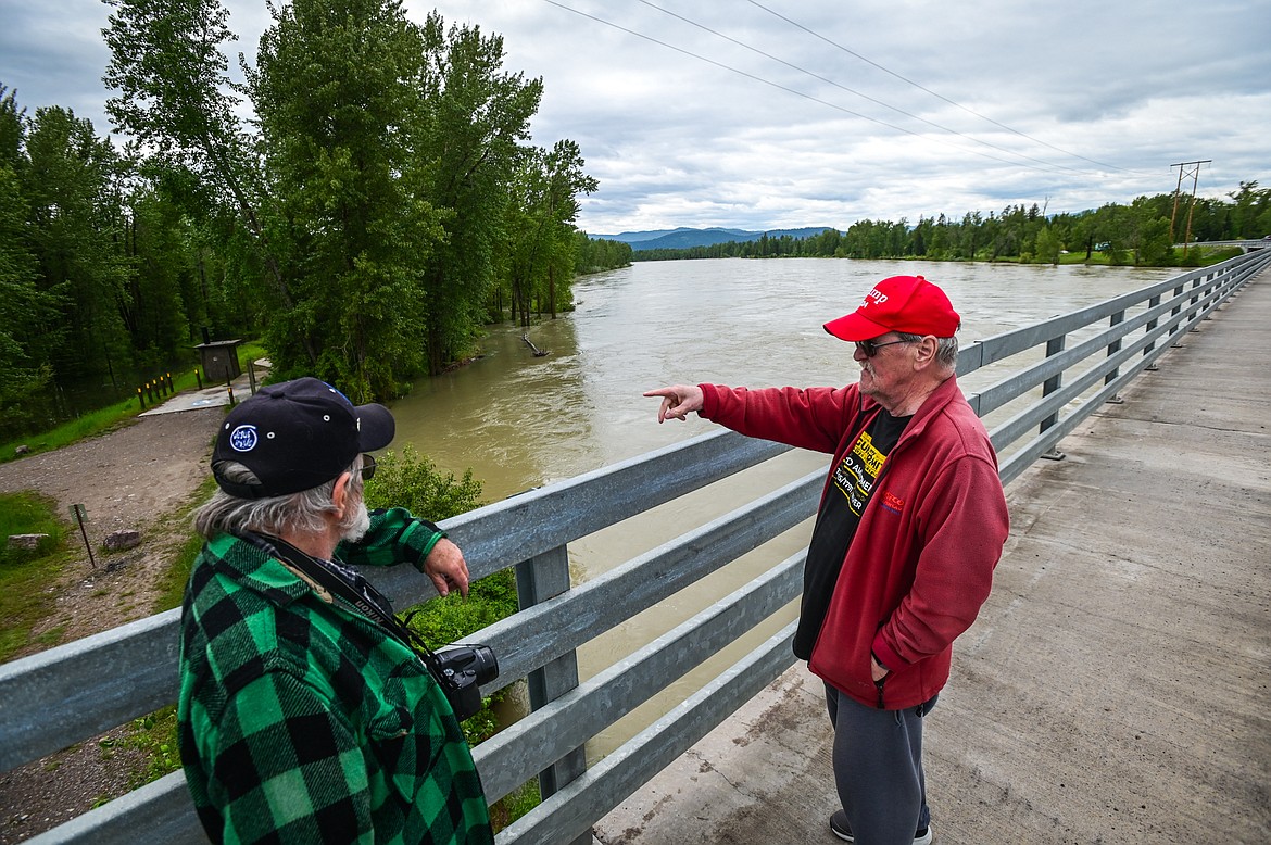 Dale Cordell and Bill McLeod watch the waters of the Flathead River from the bridge on Holt Stage on Wednesday, June 15. (Casey Kreider/Daily Inter Lake)