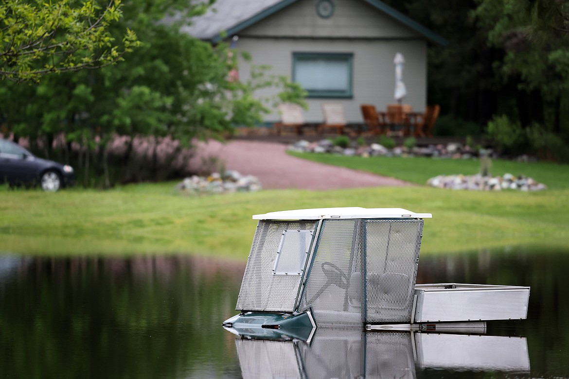 A golf cart sits beneath flood water at Meadow Lake Golf Course in Columbia Falls Wednesday, June 15. (Jeremy Weber/Daily Inter Lake)