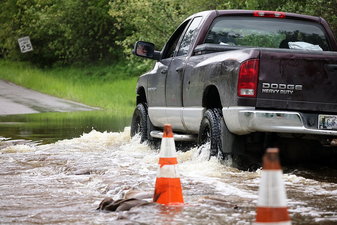 A pickup makes its way through the flooding along Garnier Creek on North Hilltop Road in Columbia Falls Wednesday, June 15. (Jeremy Weber/Daily Inter Lake)